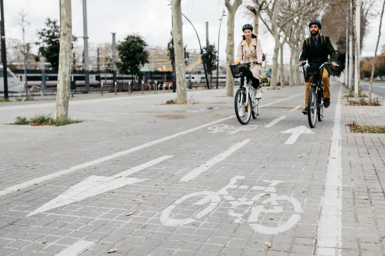 Two commuters riding bikes in a city bike lane Two commuters riding bikes in a city bike lane