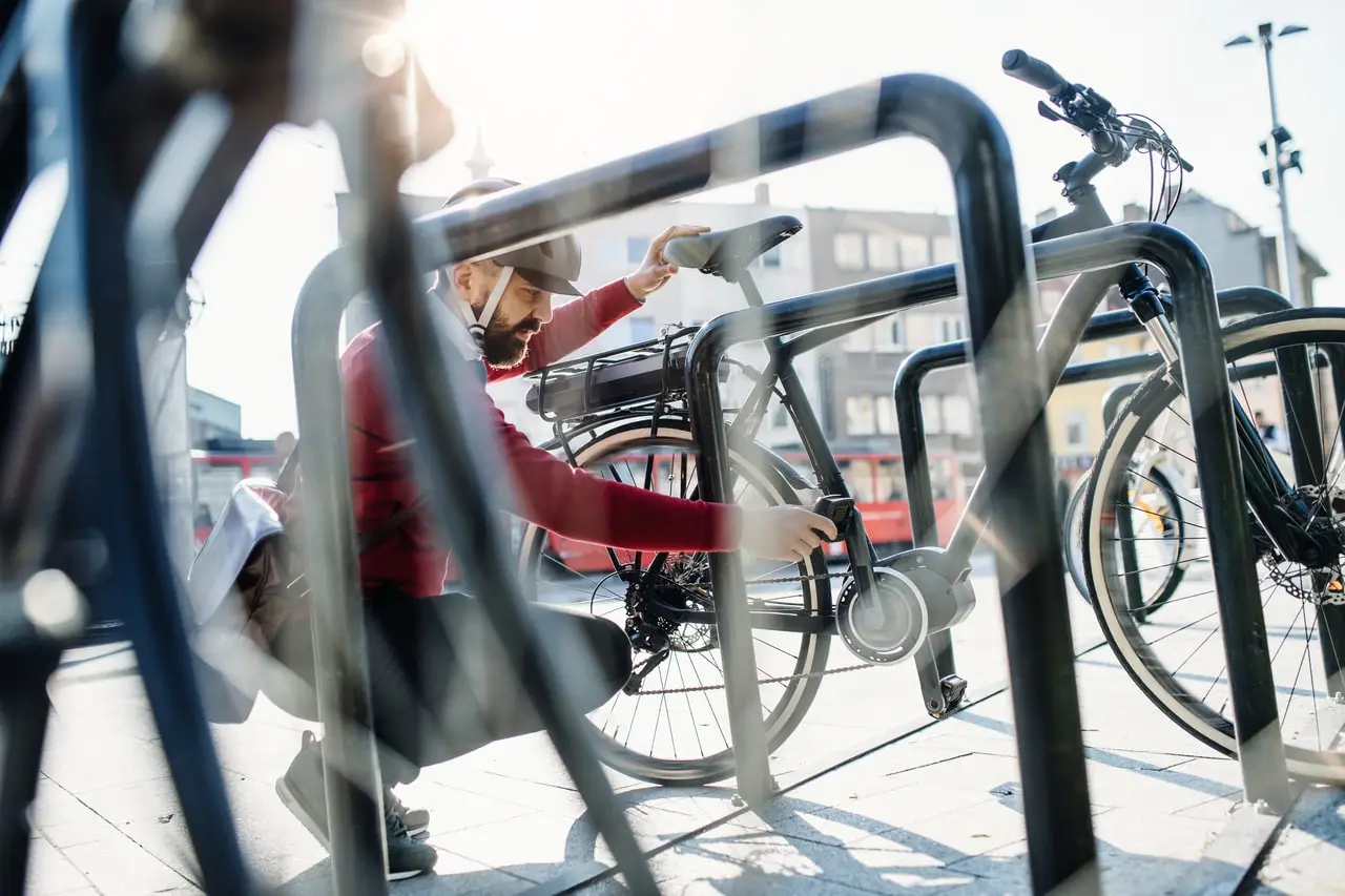 Commuter locking a bike to a city bike rack Commuter locking a bike to a city bike rack