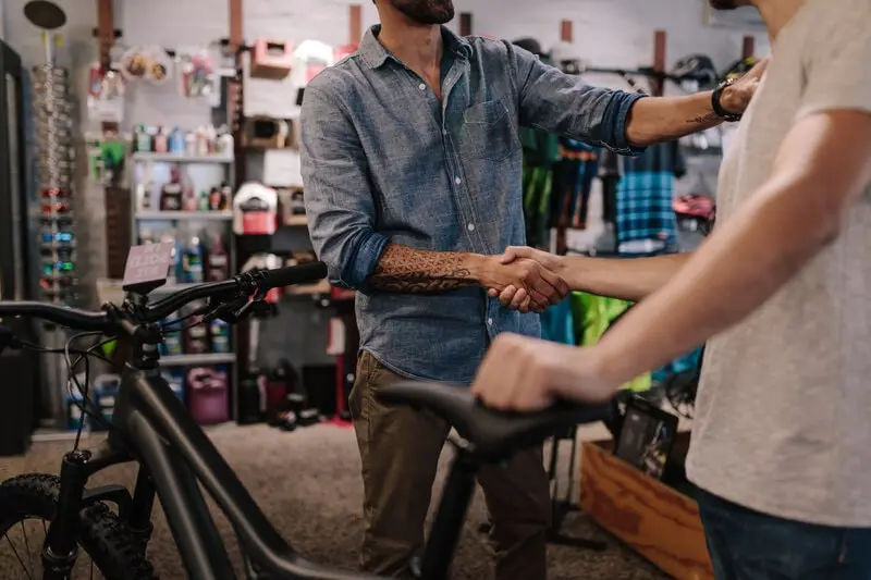 Buyer and seller shaking hands over a used bike Buyer and seller shaking hands over a used bike
