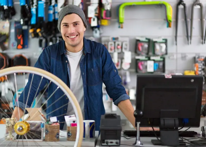 Bike shop salesperson at the counter with a wheel Bike shop salesperson at the counter with a wheel
