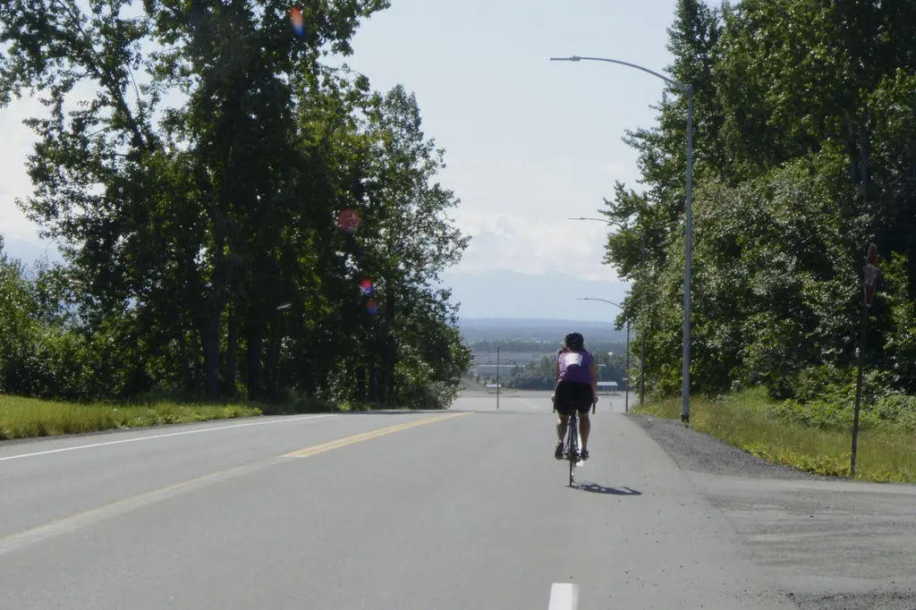 Cyclist riding a paved trail in Anchorage