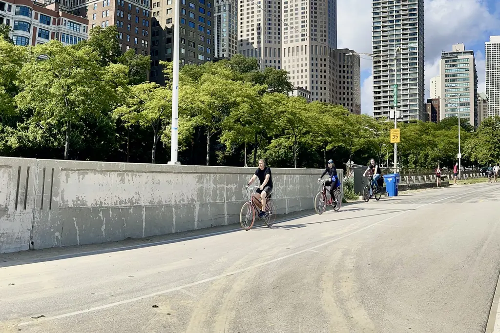 Cyclists riding along the Chicago lakefront with the skyline behind them