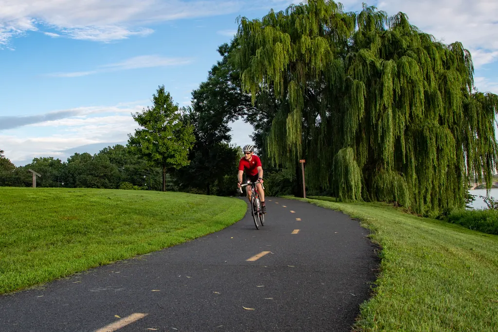 Cyclist riding a paved riverside trail in Virginia