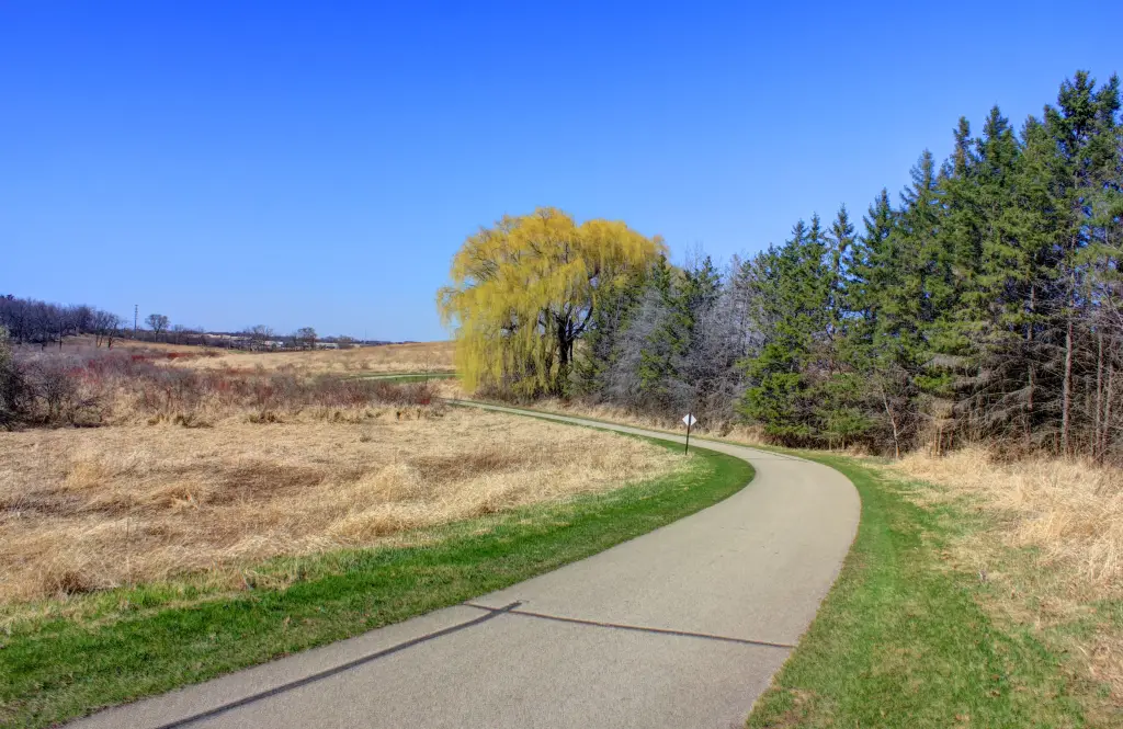 Paved bike path curving through a Madison prairie